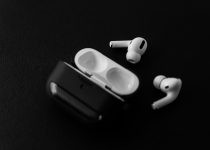 white apple earpods beside black leather case