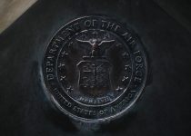 silver round coin on black textile