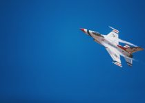 white and red jet plane hovering on sky at daytime
