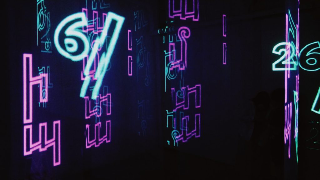 neon signs are lit up in a dark room